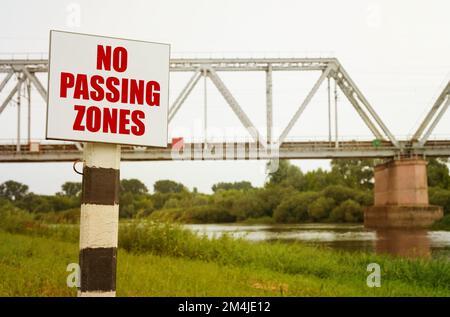 On the background of the railway bridge there is a sign with the inscription - No Passing Zones. Stock Photo