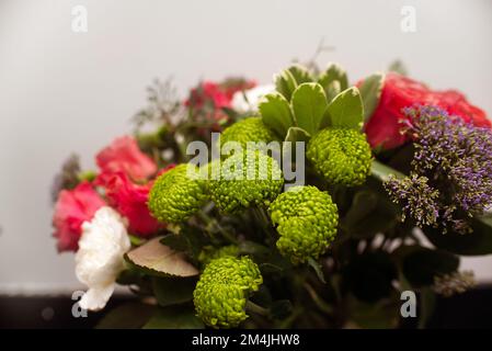 Gift flower arrangement close-up, a bouquet of mixed flowers of green chrysanthemums and carnations in a flower shop Stock Photo