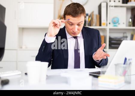 Puzzled businessman looking at papers Stock Photo