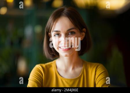 Portrait of beautiful cheerful young brunette woman smiling at camera Stock Photo