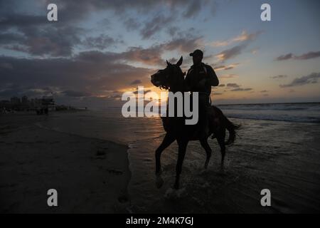 Gaza, The Gaza Strip, Palestine. 21st Dec, 2022. Palestinian man rides his horse along the beach at sunset in Gaza City. (Credit Image: © Mahmoud Issa/SOPA Images via ZUMA Press Wire) Stock Photo