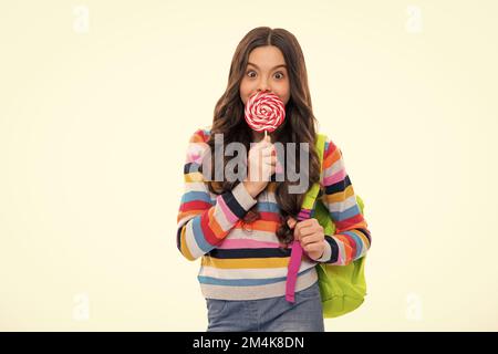 Teenage girl with candy lollipop, happy child 12, 13, 14 years old eating big sugar lollipop, sweets candy. Stock Photo