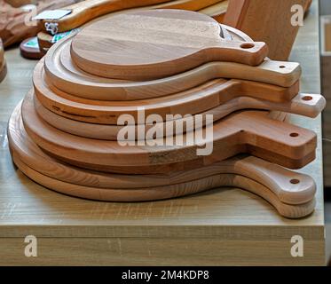 Stack of homemade wooden chopping boards sold on market Stock Photo