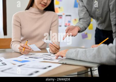 cropped image, An Asian female graphic designer discussing work with her team in the meeting. user experience and interface design concept Stock Photo