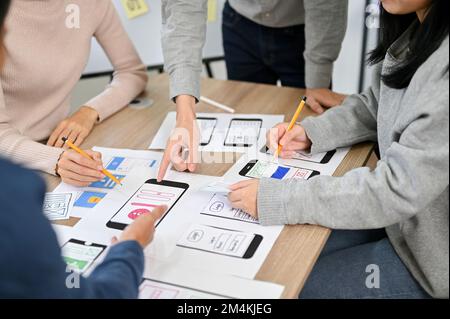 Group of millennial Asian mobile application developers startup are in the meeting, discussing and brainstorming on their new project, testing new pro Stock Photo