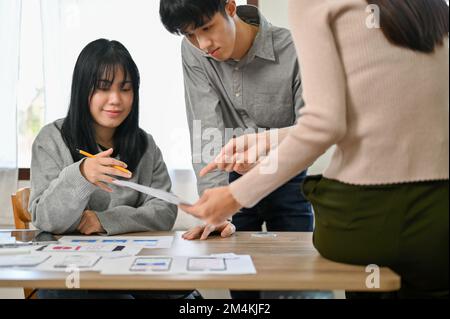 Group of millennial Asian mobile application developers startup are in the meeting, discussing and brainstorming on their new project, testing new pro Stock Photo