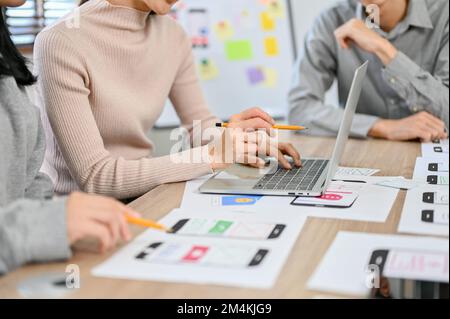 A team of professional millennial Asian website and mobile app developers are in the meeting. user experience and interface design. cropped image Stock Photo