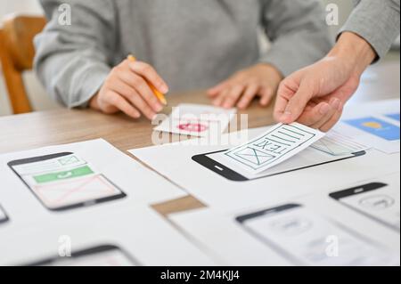 A team of mobile application interface designers are in the meeting, brainstorming and designing their application for their target user. user interfa Stock Photo