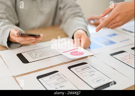 A team of mobile application interface designers are in the meeting, planning and designing their application for their target user. cropped image Stock Photo