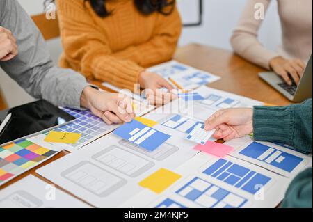 A team of professional mobile app developers and designers are discussing and brainstorming on their new mobile app interface design. startup business Stock Photo