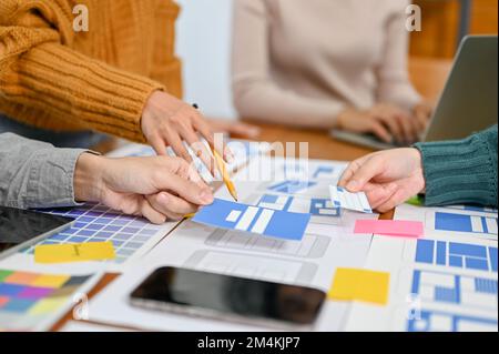 A team of professional mobile application designers are in the meeting, discussing and brainstorming user interface design. close-up image. UX UI conc Stock Photo