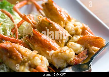 Deep fried river prawns with tamarind sauce decorated with shredded cabbage served on white plate. Stock Photo