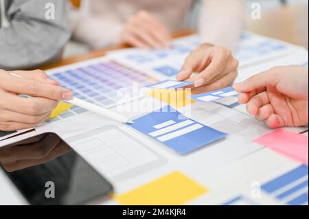 Team of mobile application designer and developer are in the meeting, discussing and brainstorming the interface design. cropped and close-up image Stock Photo