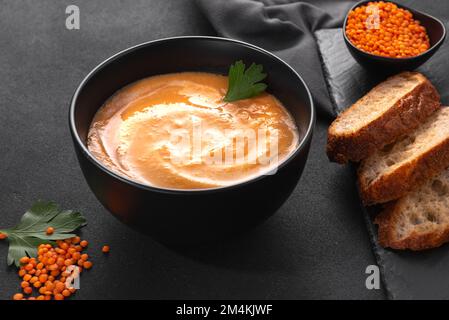 Lentil soup with red lentils whipped into a puree with cream on a dark background top view Stock Photo