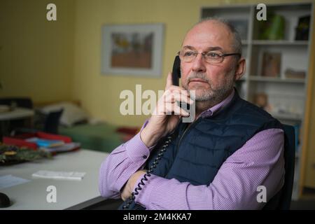 Berlin, Germany. 12th Dec, 2022. Pastoral counselor Uwe Müller from the Church Telephone Counseling Service in Berlin and Brandenburg sits by the phone in an office of the Diakonie Volunteer Center. Demand for telephone counseling is particularly high at Christmas. Credit: Jens Kalaene/dpa/Alamy Live News Stock Photo