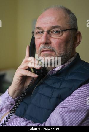 Berlin, Germany. 12th Dec, 2022. Pastoral counselor Uwe Müller from the Church Telephone Counseling Service in Berlin and Brandenburg sits by the phone in an office of the Diakonie Volunteer Center. The demand for telephone counselling is particularly high at Christmas. (to dpa Telefonseelsorge seeks volunteers - increasingly difficult) Credit: Jens Kalaene/dpa/Alamy Live News Stock Photo