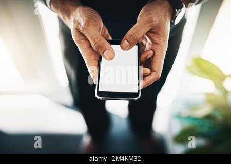 Doing business in the age of the mobile app. a businessman using a mobile phone in an office. Stock Photo