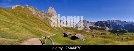 Panorama of Geislerspitzen massif on Seceda with walking path, grass, huts and view to Odle mountains, Val (Valley) Gardena, Dolomites, Italy Stock Photo