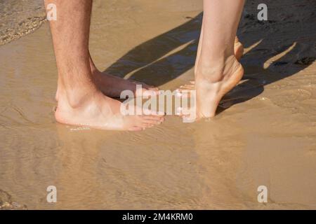 male and female feet in sea water bottom view in the sun Stock Photo