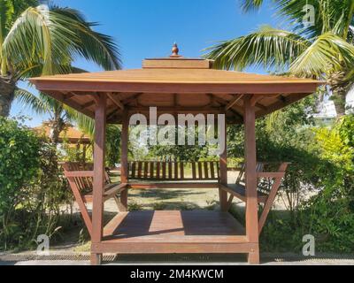 A wooden Thai gazebo with coconut palm tree and lanscape in Phuket, Thailand. Asian architecture, park and outdoors concept. Stock Photo