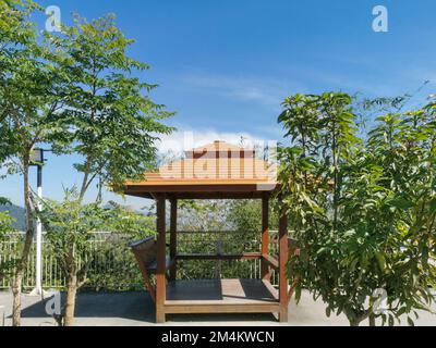 A wooden Thai gazebo with coconut palm tree and lanscape in Phuket, Thailand. Asian architecture, park and outdoors concept. Stock Photo