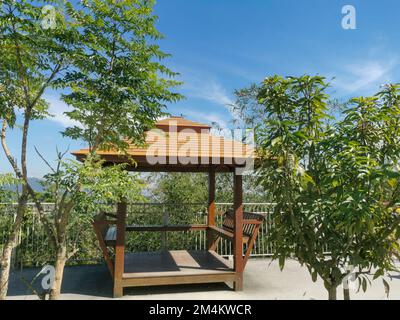 A wooden Thai gazebo with coconut palm tree and lanscape in Phuket, Thailand. Asian architecture, park and outdoors concept. Stock Photo