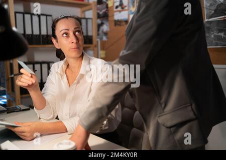 Woman's colleagues in police office. Diverse detectives coworkers analyzing data and discussing criminal case in agency office. Copy space Stock Photo