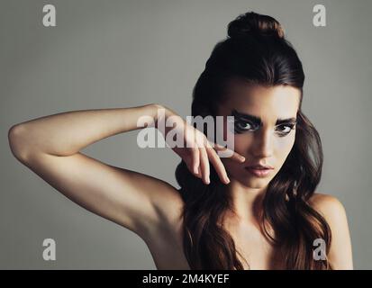 Be your own inspiration. Studio shot of an attractive young woman wearing bold eye makeup. Stock Photo