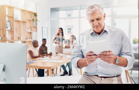 Tablet, business and senior man in office reading email, researching or internet browsing. Technology, company and elderly male employee with Stock Photo
