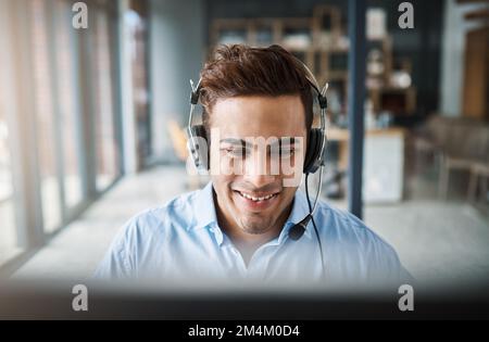 Always pleasant and professional. a handsome young man working in a call center. Stock Photo