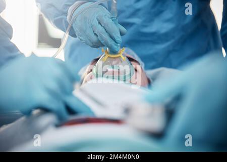 Doctors, surgery and oxygen mask with a medicine team in scrubs operating on a man patient in a hospital. Doctor, nurse and teamwork with a medical Stock Photo