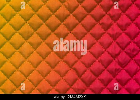 red stitched quilted bag cloth background closeup Stock Photo