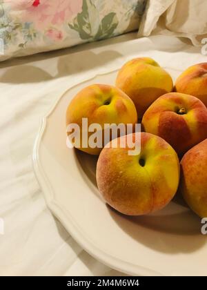 Lovely peaches are on the white dish Stock Photo