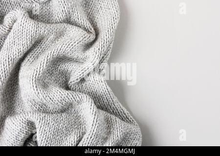 Cozy gray knitted blanket with large knitting needles on a gray background with a place for text. Stock Photo