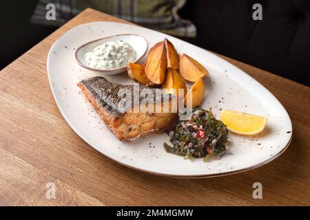 Fish flounder fried with potatoes, vegetables and sauce. Healthy food, close up Stock Photo