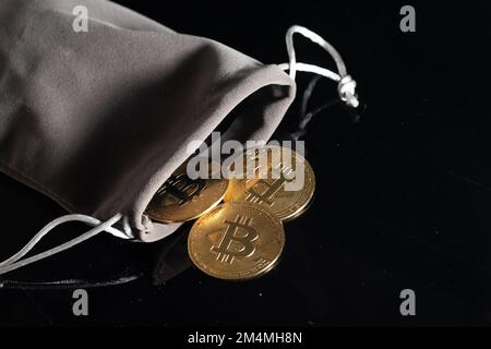 Close up Bitcoins in pouch wallet. Gold crypto coins on black table isolated background Blockchain and financial technology concept Stock Photo