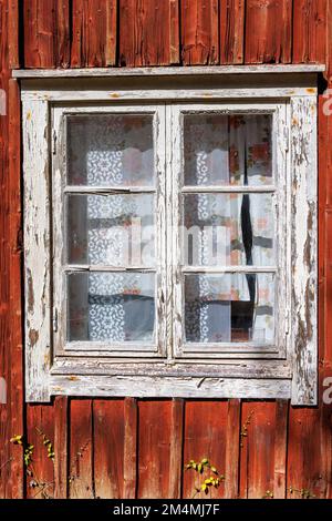 Window on a red wooden cottage Stock Photo