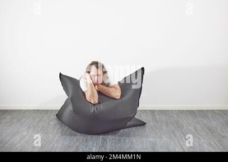 Man on beanbag in relaxing pose Stock Photo