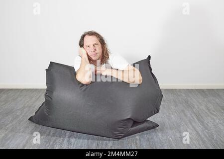 Man on beanbag in relaxing pose Stock Photo