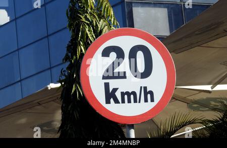 A road sign of 20 KMH twenty Kilometers per hour speed limit in the slow lane near gateway, restaurants and cafes, Prohibitory traffic Speed limit sig Stock Photo