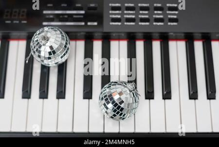 Christmas ball on piano keys. Carol music concept Stock Photo