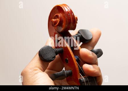 Close up view hand on Musical instrument acoustic guitar headstock adjust tuning pegs Stock Photo