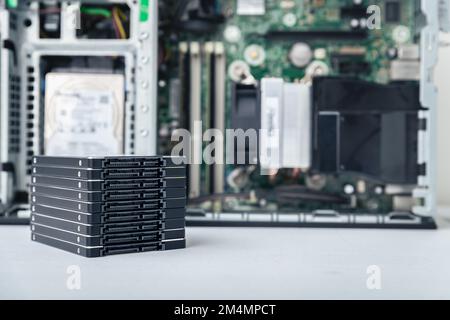 Closed-up view of SSD hard disk drives with a PC in the background. Computer upgrade, repair and data recovery concept Stock Photo