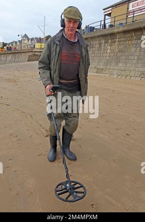 Man using a metal detector, on a beach, near Filey, North Yorkshire, England, UK, YO14 9LA Stock Photo