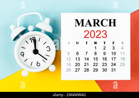 March 2023 Monthly calendar year with alarm clock on colourful background. Stock Photo