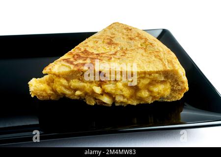Spanish omelette on black plate. Stock Photo