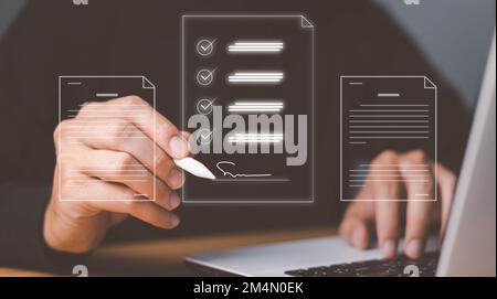 A businessman using a pen signing electronic documents on digital documents on a virtual screen Stock Photo