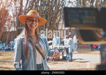 Exterior shot of young beautiful woman vlogging, Happy smiling young vlogger possing on the camera. Stock Photo
