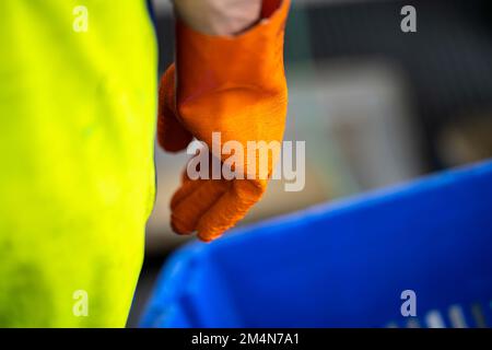 fisherman wearing waterproof clothes and gloves on a fishing boat in australia in summer Stock Photo