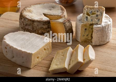 French cheese board with a variation of cheese, Tommette de Montagne, Bresse Bleu and Le coq de Bruyere close up Stock Photo